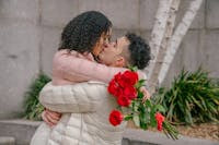 pareja de novios con flores dandose un abrazo y beso